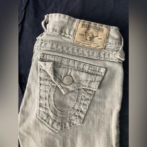 Gray True Religion Jeans with white stitching.